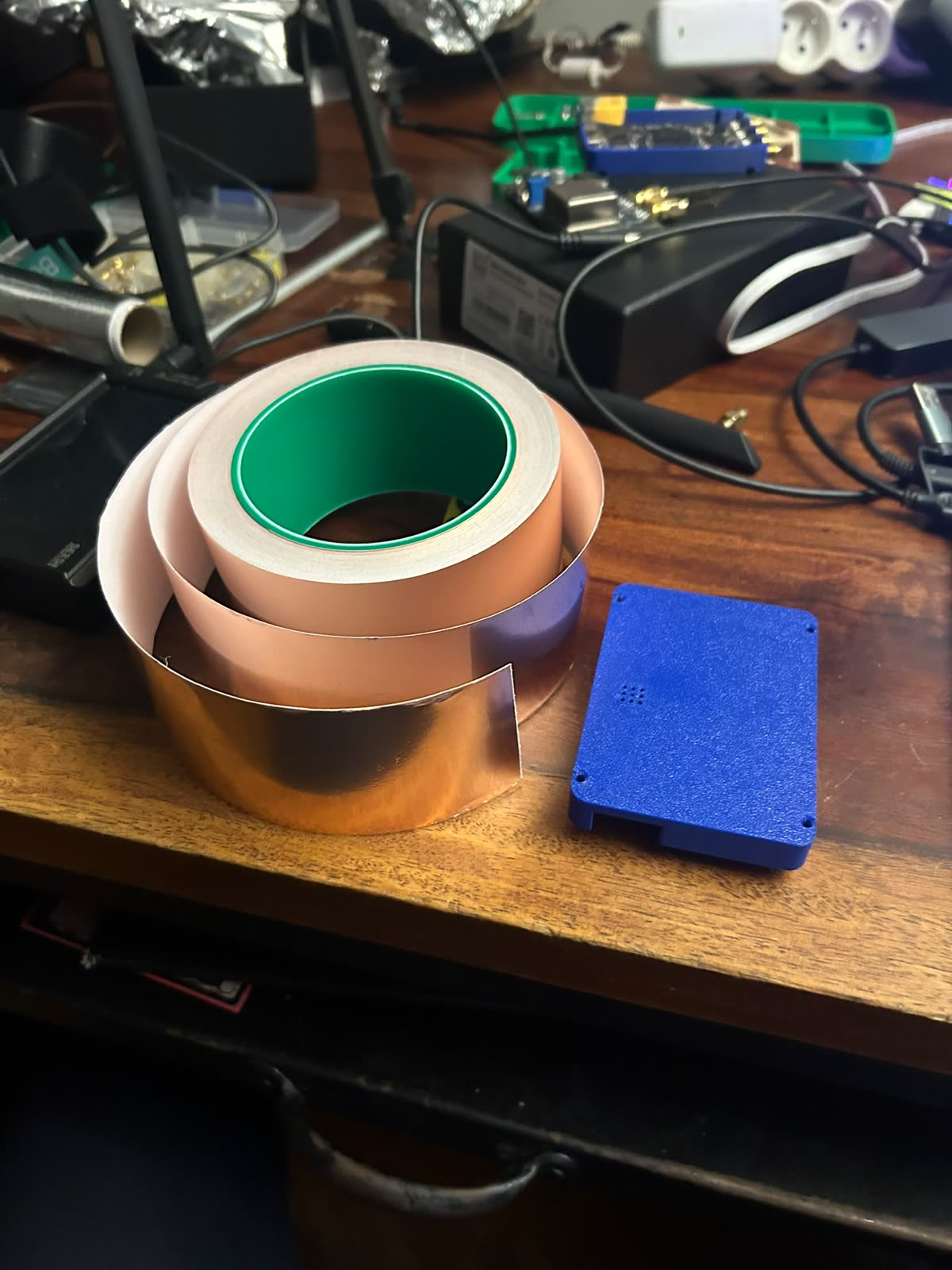 Rouleaux de scotch cuivre et un boîtier imprimé en 3D bleu sur le bureau